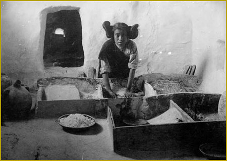 Pueblo woman grinding corn at Hopi.